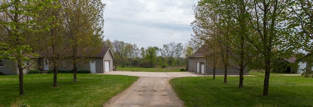 15105 Carpenter Rd, Three Oaks, MI 49128 - view of side of home with concrete driveway, a garage, and a lawn