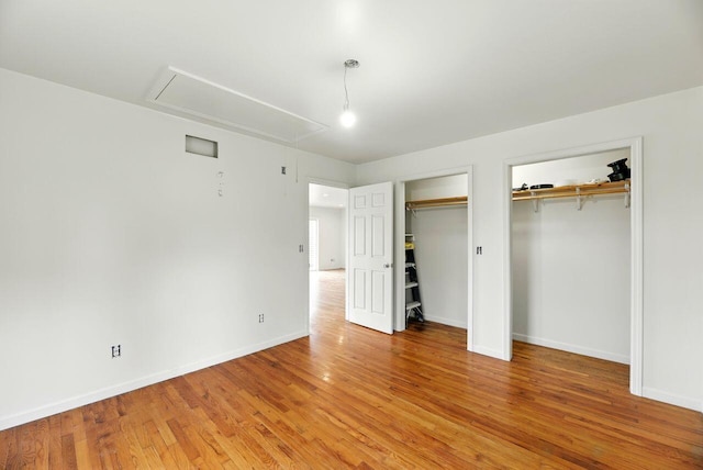 15105 Carpenter Rd, Three Oaks, MI 49128 - unfurnished bedroom featuring attic access, multiple closets, light wood-style floors, and baseboards