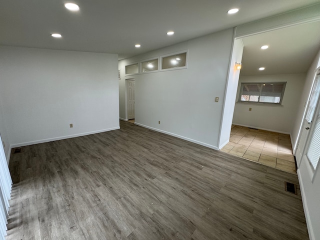 unfurnished room with recessed lighting, wood finished floors, baseboards, and healthy amount of natural light
