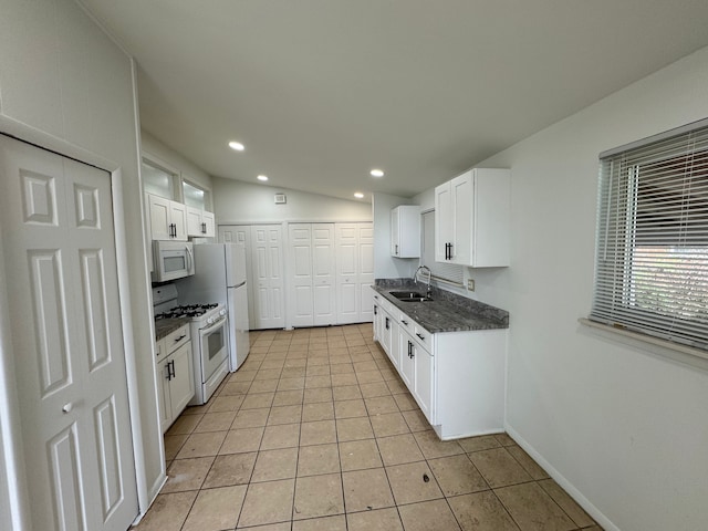 kitchen with white appliances, a sink, light tile patterned flooring, white cabinetry, and recessed lighting