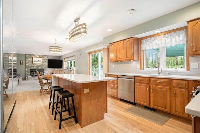 10420 Roger St, Portage, MI 49002 - kitchen with a sink, stainless steel dishwasher, a kitchen island, light wood-style floors, and light countertops