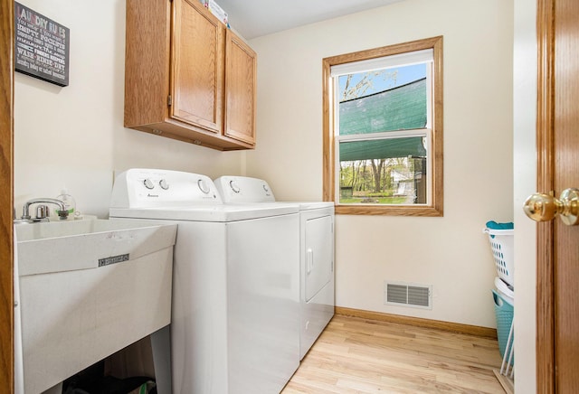 10420 Roger St, Portage, MI 49002 - washroom with cabinet space, washing machine and clothes dryer, light wood-style flooring, and baseboards