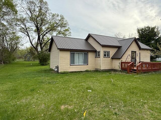 400 E Michigan Ave, Hesperia, MI 49421 - rear view of property with a deck, a lawn, and metal roof