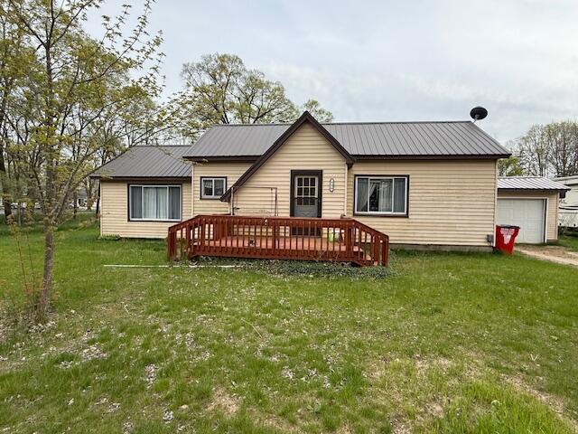 400 E Michigan Ave, Hesperia, MI 49421 - back of property featuring a wooden deck, a yard, and metal roof