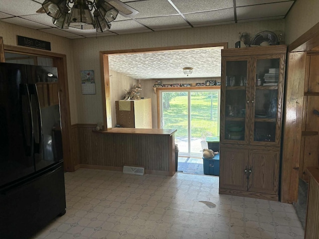 400 E Michigan Ave, Hesperia, MI 49421 - dining room featuring light flooring, a ceiling fan, a wainscoted wall, and wooden walls