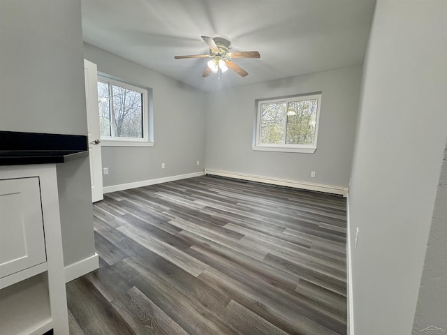 3339 S Cabaret Trl, Saginaw, MI 48603 - unfurnished living room featuring a baseboard radiator, a ceiling fan, baseboards, and dark wood-style floors