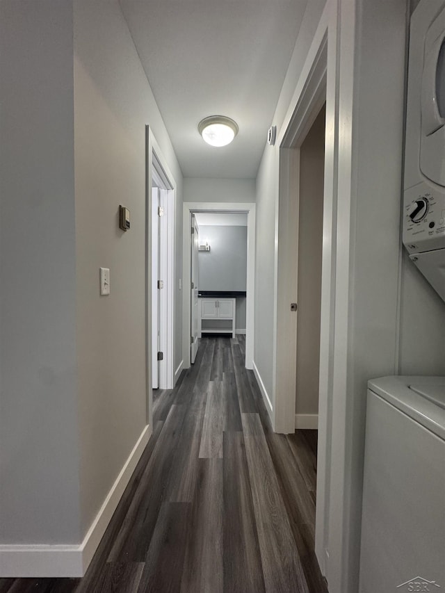 3339 S Cabaret Trl, Saginaw, MI 48603 - hallway featuring stacked washer / dryer, baseboards, and dark wood-style floors