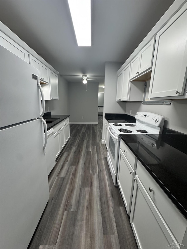 3339 S Cabaret Trl, Saginaw, MI 48603 - kitchen with white appliances, dark countertops, white cabinets, and dark wood-style floors