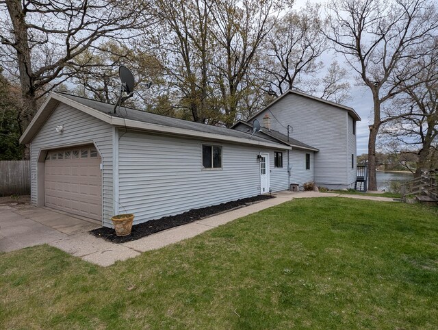 view of side of home featuring a detached garage and a water view