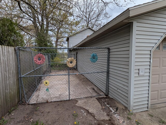 view of property exterior with fence, a gate, and a garage