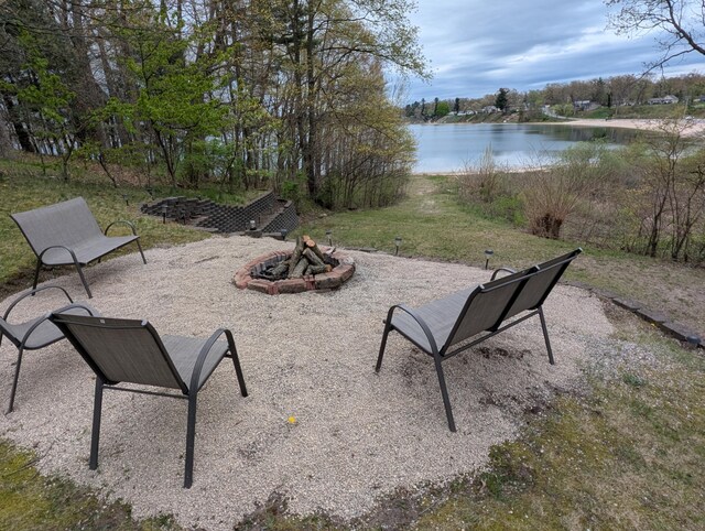 view of patio featuring an outdoor fire pit and a water view
