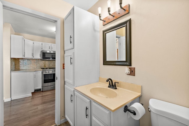 5657 Harding Ave, Muskegon, MI 49442 - bathroom featuring vanity, wood finished floors, and decorative backsplash