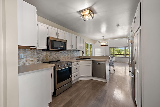 5657 Harding Ave, Muskegon, MI 49442 - kitchen featuring stainless steel appliances, a peninsula, a chandelier, white cabinets, and tasteful backsplash