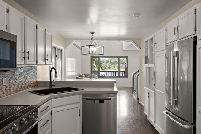 5657 Harding Ave, Muskegon, MI 49442 - kitchen featuring stainless steel appliances, a peninsula, white cabinetry, and a chandelier
