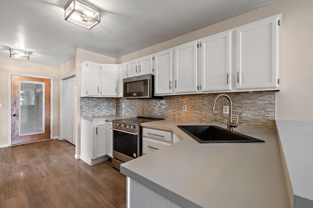5657 Harding Ave, Muskegon, MI 49442 - kitchen featuring appliances with stainless steel finishes, white cabinets, dark wood finished floors, and tasteful backsplash
