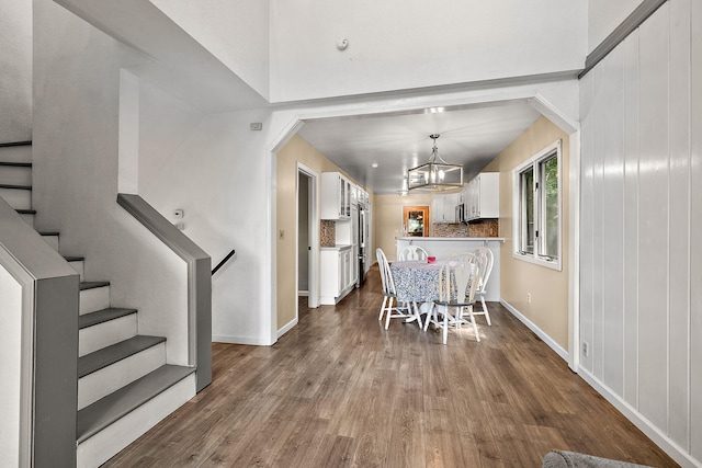 5657 Harding Ave, Muskegon, MI 49442 - dining area featuring a chandelier, dark wood-type flooring, stairway, and arched walkways