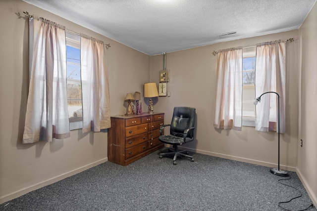 carpeted office space featuring a textured ceiling and baseboards