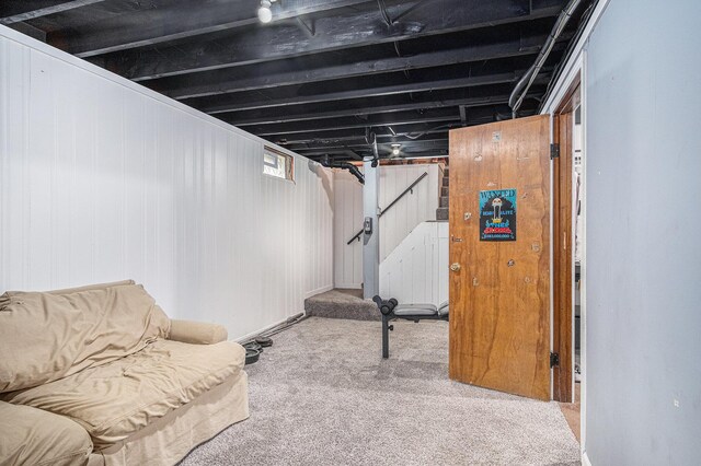 below grade area featuring stairs and carpet