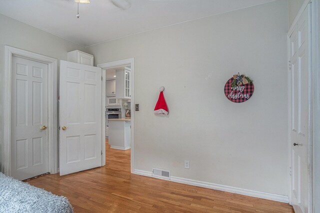 unfurnished bedroom with light wood finished floors and baseboards