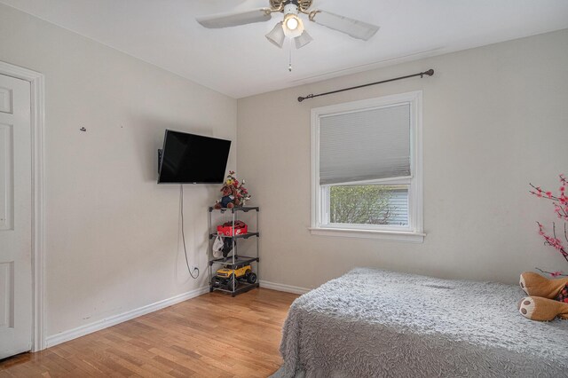 bedroom with light wood-type flooring, baseboards, and a ceiling fan