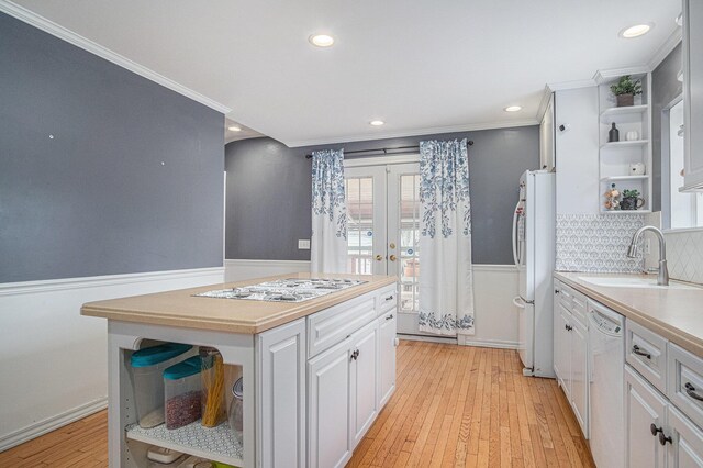 kitchen with open shelves, a sink, white appliances, crown molding, and light countertops