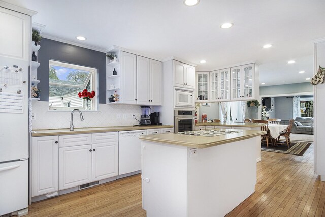 kitchen featuring white appliances, a sink, recessed lighting, light wood-style floors, and backsplash