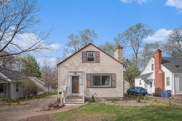 bungalow featuring a front lawn and a chimney