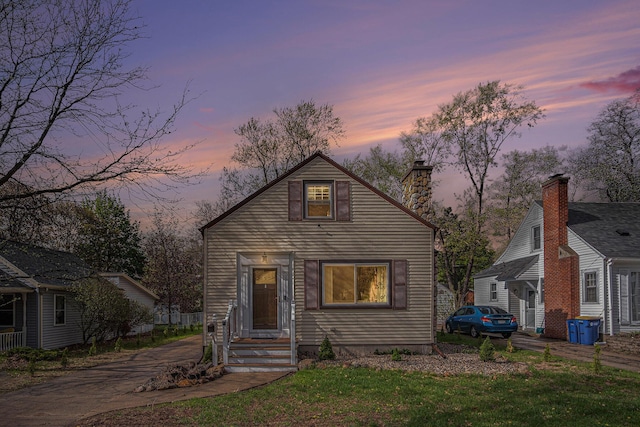 bungalow-style house with a chimney and a front yard