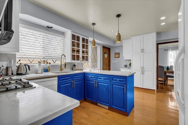 18579 Jeanette St, Southfield, MI 48075 - kitchen with a sink, blue cabinetry, a peninsula, white cabinets, and recessed lighting