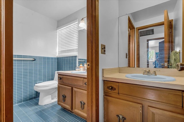 18579 Jeanette St, Southfield, MI 48075 - bathroom featuring tile patterned floors, vanity, toilet, wainscoting, and tile walls