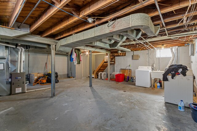 basement featuring washer / clothes dryer, stairs, a sink, and heating unit