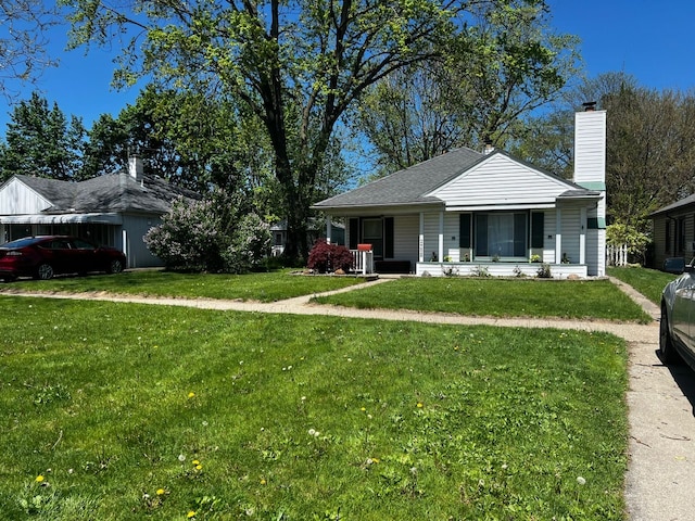 view of front of property with a front yard, a porch, and a chimney