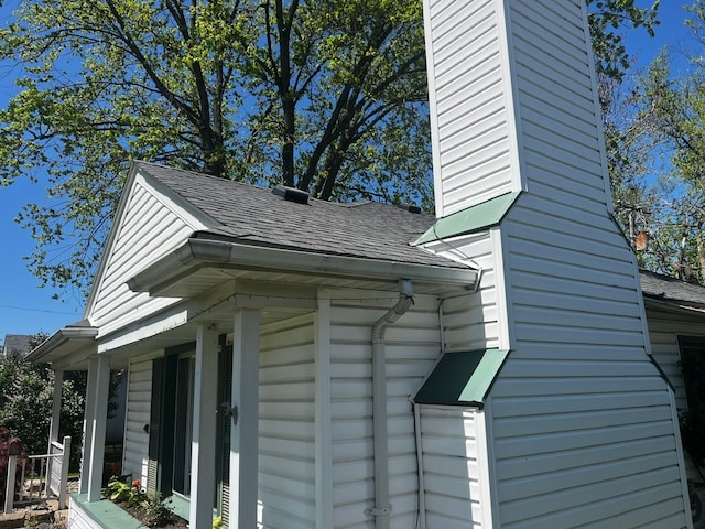 view of side of home with a shingled roof
