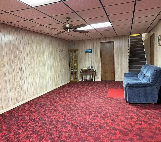 31915 M 60, Leonidas, MI 49066 - living area featuring a ceiling fan, stairs, carpet, a drop ceiling, and wood walls
