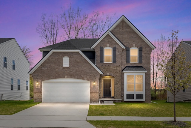 view of front of home with a front lawn, brick siding, driveway, and a garage
