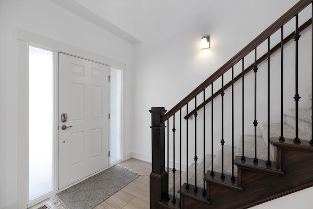 entrance foyer featuring stairs, baseboards, and wood finished floors