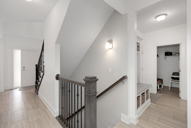 corridor with an upstairs landing and baseboards