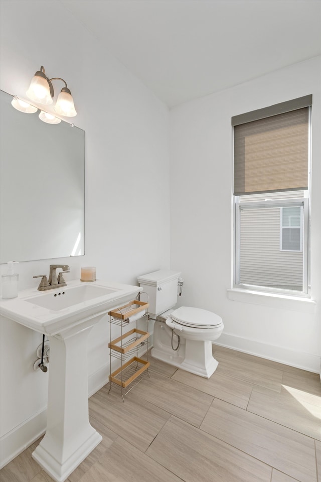 half bathroom with toilet and baseboards