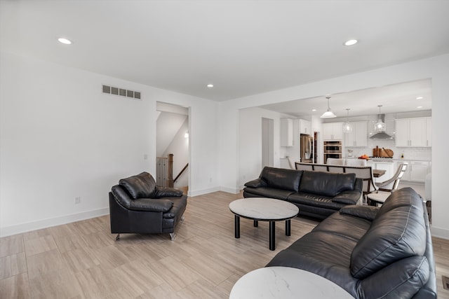 living area featuring recessed lighting and baseboards