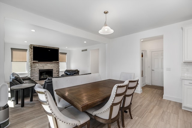 dining space featuring plenty of natural light, a fireplace, baseboards, and recessed lighting
