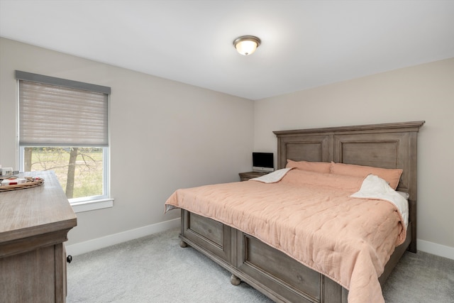 bedroom featuring light colored carpet and baseboards