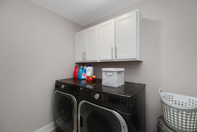 clothes washing area featuring cabinet space, washer and clothes dryer, and baseboards