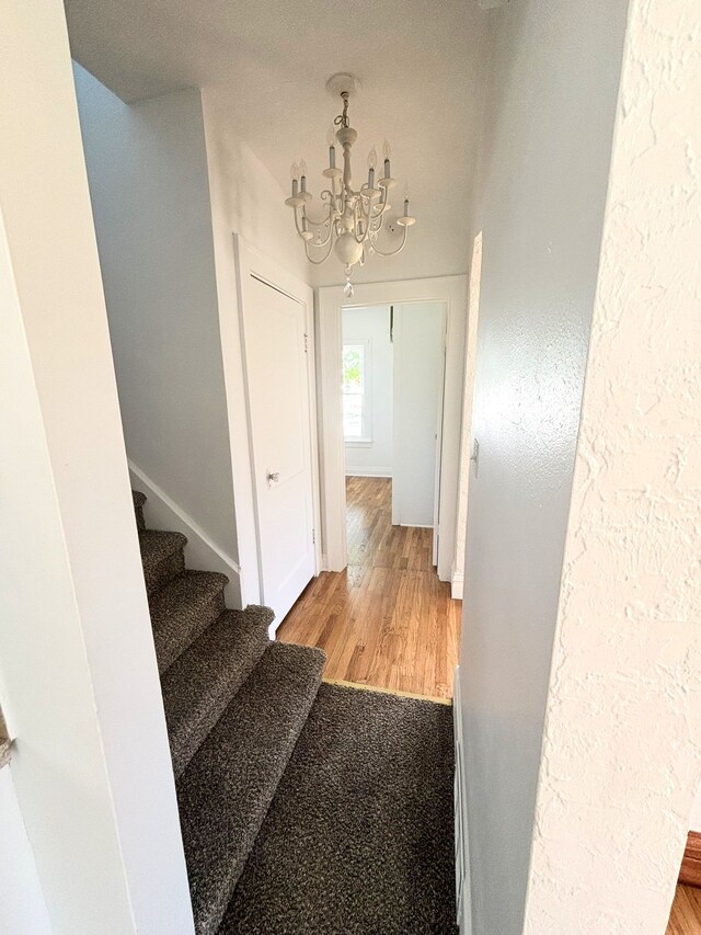 1040 Ronald St, Flint, MI 48507 - stairway with a chandelier, wood finished floors, and baseboards