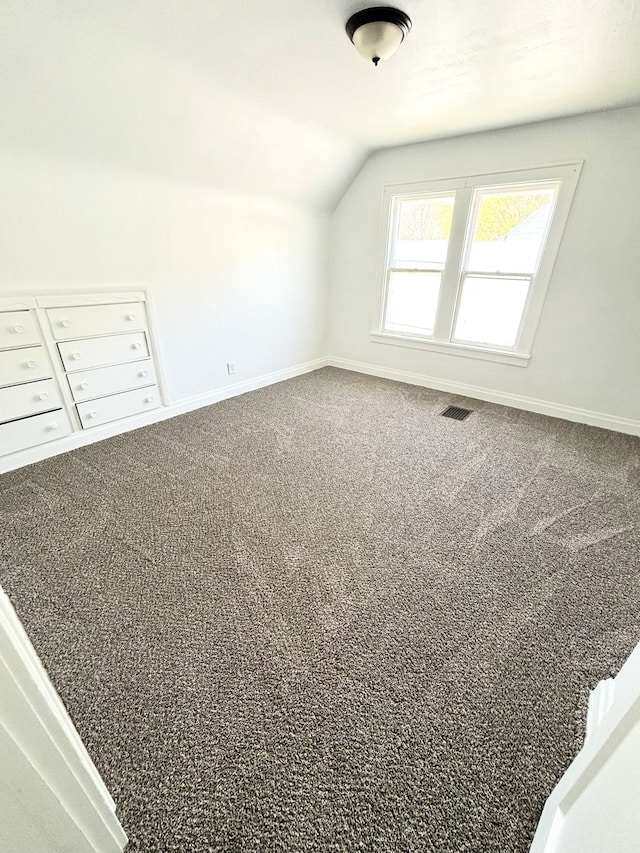 additional living space with lofted ceiling, baseboards, carpet, and mail area