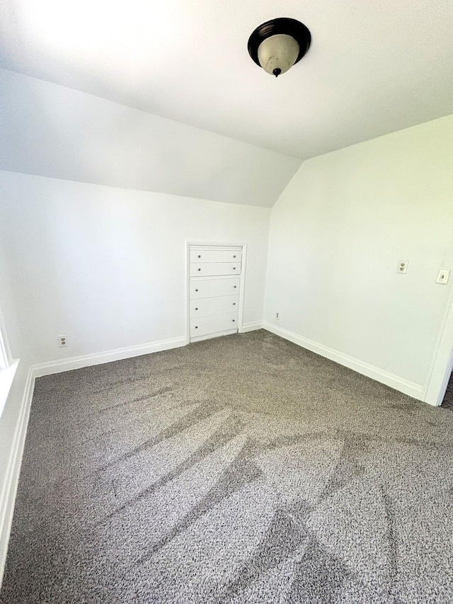 additional living space featuring carpet flooring, lofted ceiling, and baseboards