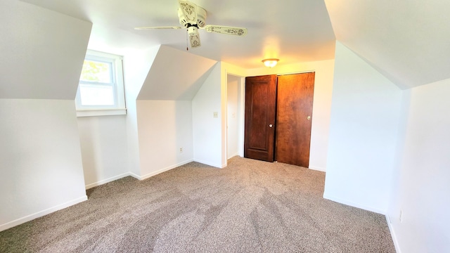additional living space with lofted ceiling, carpet flooring, a ceiling fan, and baseboards