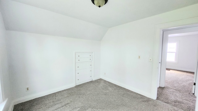 additional living space with carpet flooring, lofted ceiling, and baseboards