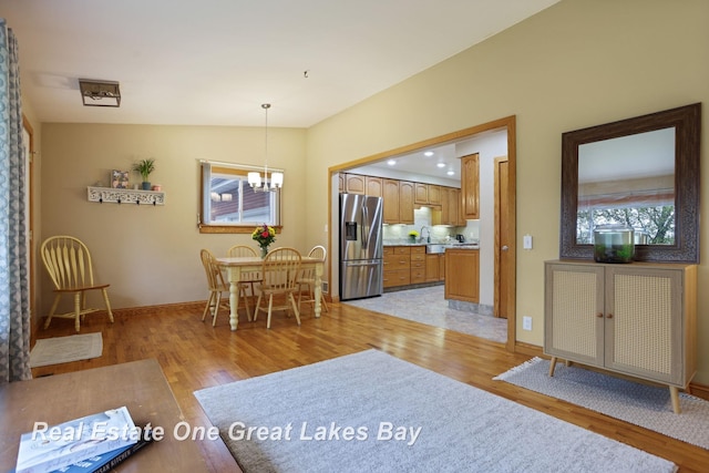 1416 Airfield Ln, Midland, MI 48642 - dining room with a chandelier, light wood-style flooring, baseboards, and lofted ceiling