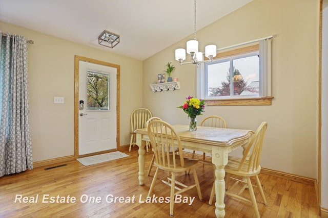 1416 Airfield Ln, Midland, MI 48642 - dining area with vaulted ceiling, healthy amount of natural light, a chandelier, wood finished floors, and baseboards