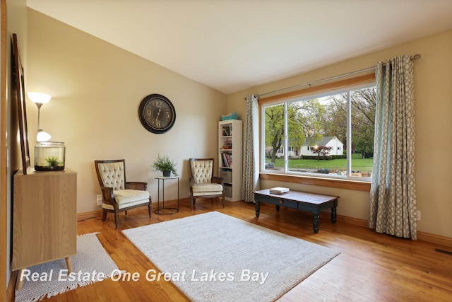 1416 Airfield Ln, Midland, MI 48642 - living area with wood finished floors, baseboards, and vaulted ceiling